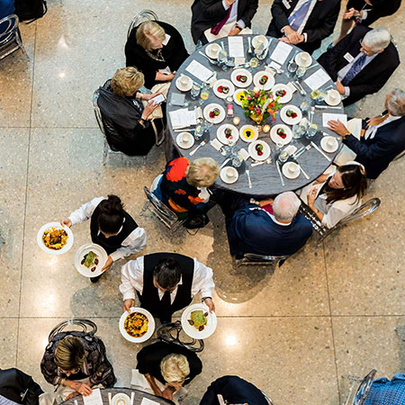 Waiter with food move among tables of guests