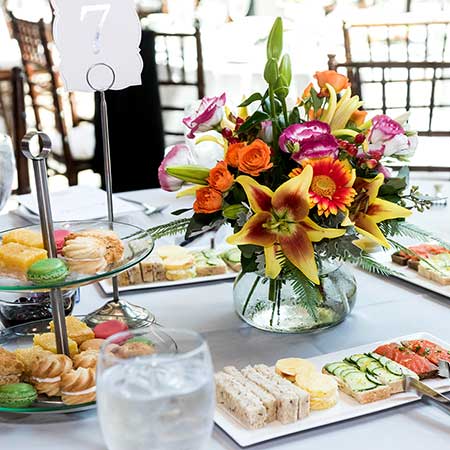 Table top with a beautiful floral arrangement surround by snacks 